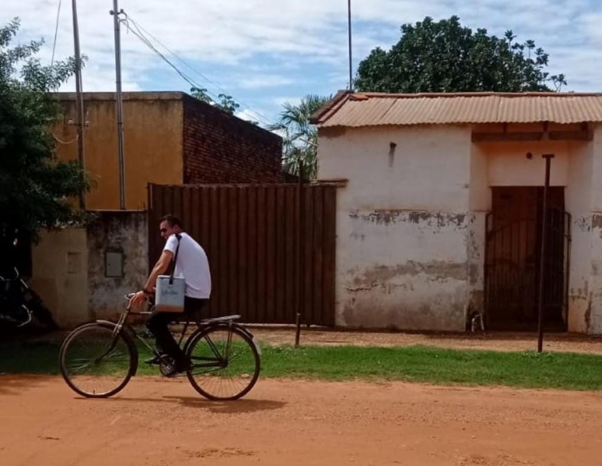 En bicicleta lleva vacunas casa por casa para que personas mayores sean inmunizadas. Foto: MSP BS.