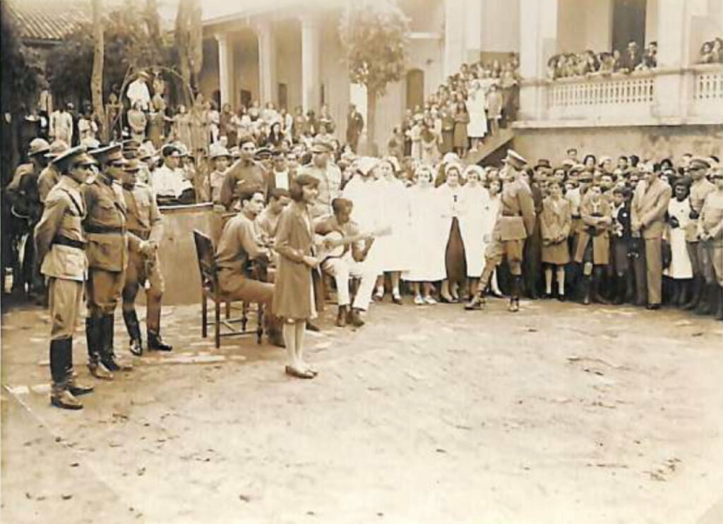 Niña cantando ante tropas y enfermeras prestas a partir al Chaco, en el patio de la antigua Escuela Militar, ca. 1932. Colección David Velázquez Seiferheld.