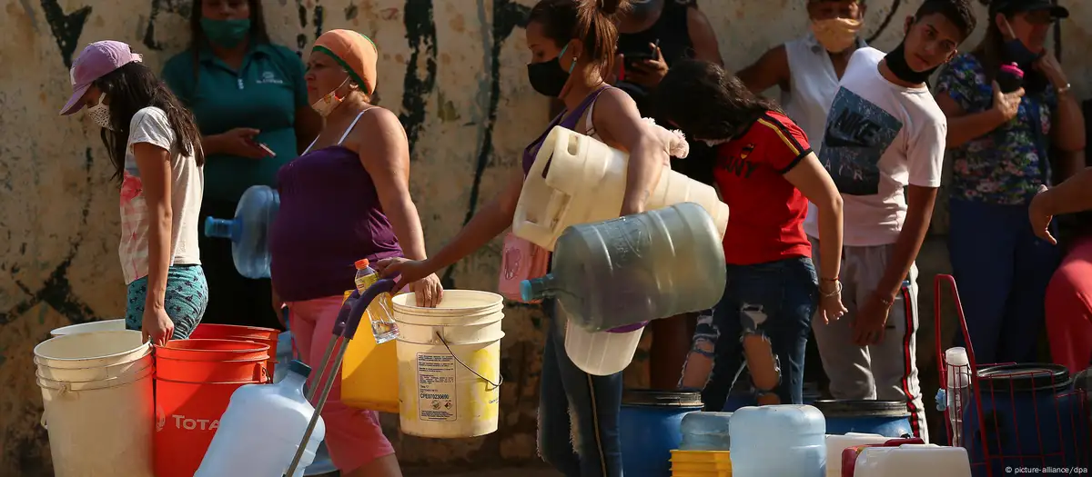 Personas hacen cola con bidones para llenar de agua en Venezuela. Cada vez son más las personas afectadas por la escasez de agua en Venezuela. Imagen: picture-alliance/dpa