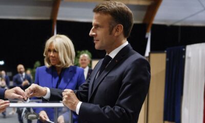 El presidente francés, Emmanuel Macron, introduce su voto en la urna junto a su esposa. (Reuters/Mohammed Badra/El Confidencial)