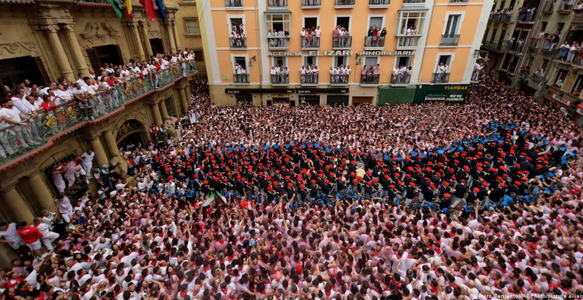 La multitud escucha el pregón del alcalde desde el balcón del Ayuntamiento antes del "chupinazo" que da inicio a los festejos.Imagen: Alvaro Barrientos/AP Photo/picture alliance.