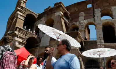 Turistas se cubren del sol frente al emblemático Coliseo en Roma. (Foto de archivo: 29.07.2024) Imagen: Fabio Frustaci/Ansa/Zuma/picture alliance