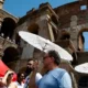 Turistas se cubren del sol frente al emblemático Coliseo en Roma. (Foto de archivo: 29.07.2024) Imagen: Fabio Frustaci/Ansa/Zuma/picture alliance