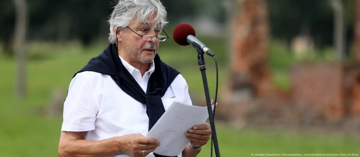 El sinto Christian Pfeil dando un discurso conmemorativo el 2 de agosto de 2022 en el antiguo campo de exterminio Auschwitz-Birkenau. Imagen: Jarosław Praszkiewic./Dokumentations- und Kulturzentrum Deutscher Sinti und Roma