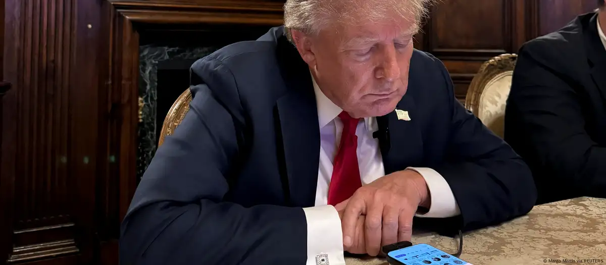 Donald Trump mirando sus redes sociales.Foto: X