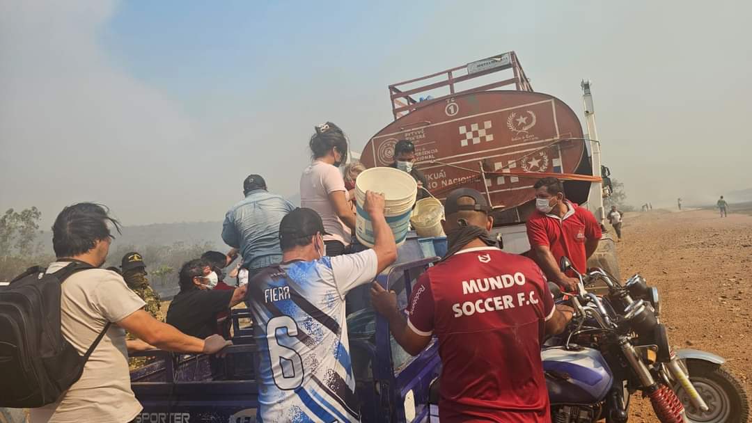 Con lo que puedan, acarrean agua para combatir incendio. Foto: Gentileza.