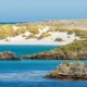 Playa de arena blanca cerca de Puerto Stanley, en un día soleado en las islas Malvinas. Imagen: Steven Heap/Zoonar/picture alliance