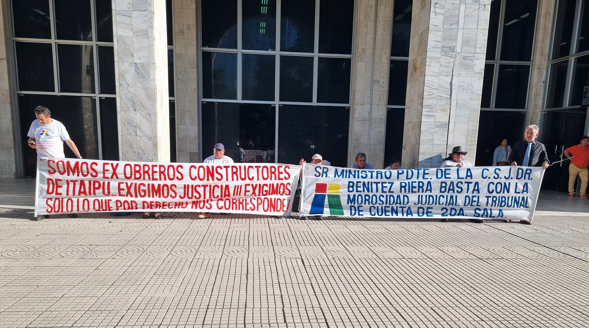 Exobreros de Itaipú reclaman el cobro de haberes atrasados frente al Palacio de Justicia. Foto: Roberto Pérez.