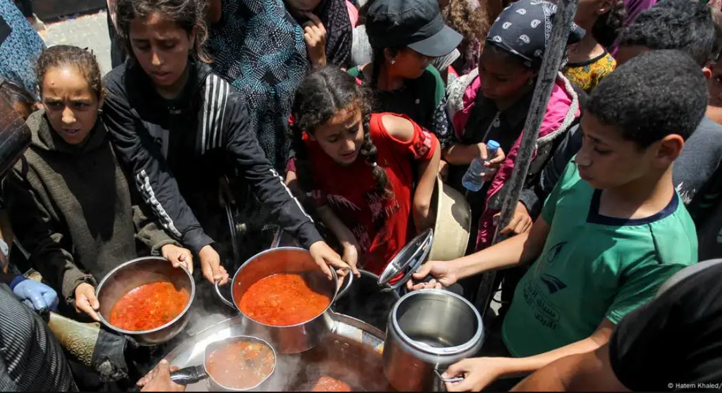 Menores palestinos reciben comida en una cocina de caridad en el sur de Gaza.Imagen: Hatem Khaled/REUTERS/DW