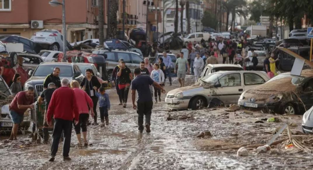 Varias personas caminan por una de las calles afectadas en Valencia, tras las fuertes lluvias causadas por la DANA. Foto: Archivo.