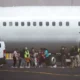 Deportados subiendo al avión escoltados por oficiales de la policía migratoria ICE. Foto: DW