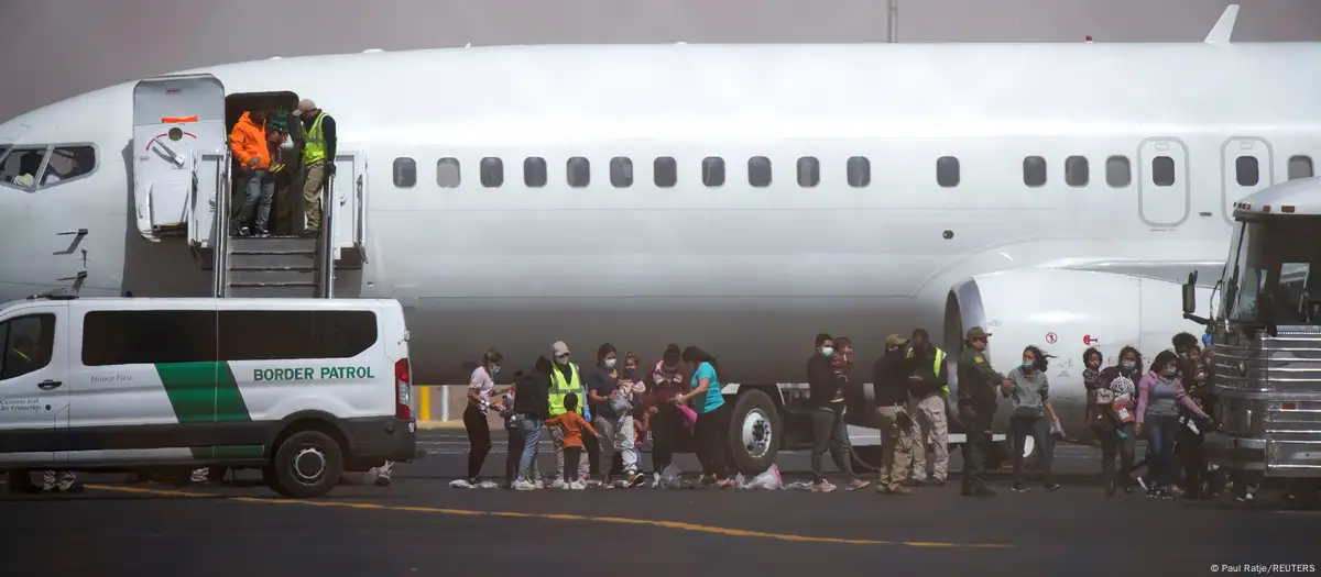 Deportados subiendo al avión escoltados por oficiales de la policía migratoria ICE. Foto: DW