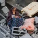 Una mujer llora sentada sobre los escombros de su casa, destruida por un ataque israelí, en el campo de refugiados de Nuseirat, en el centro de la Franja de Gaza. Foto: DW