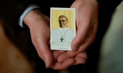 Un sacerdote español muestra una figura con la imagen del papa Francisco. Foto: DW.