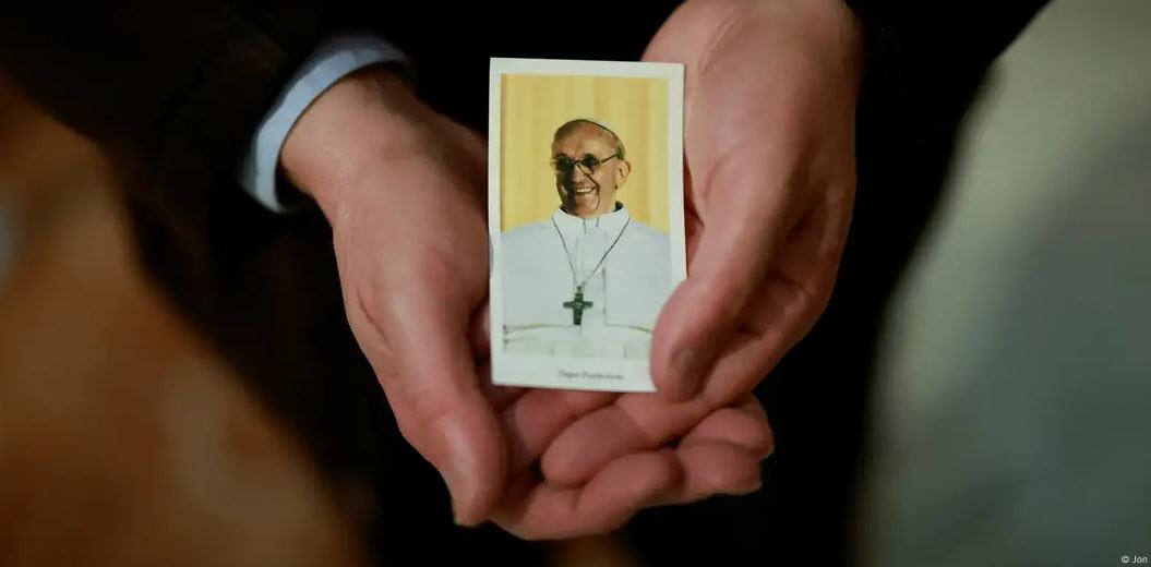 Un sacerdote español muestra una figura con la imagen del papa Francisco. Foto: DW.